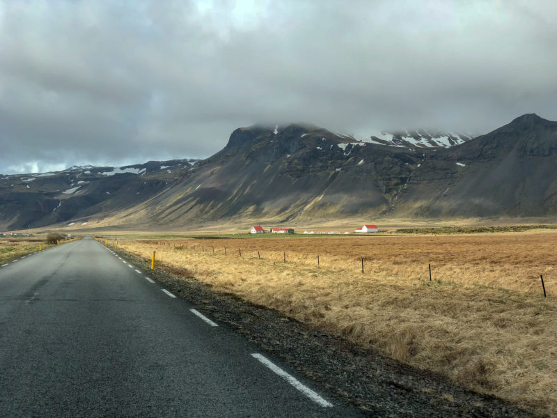 Straßen auf Island mit einer Farm daneben.